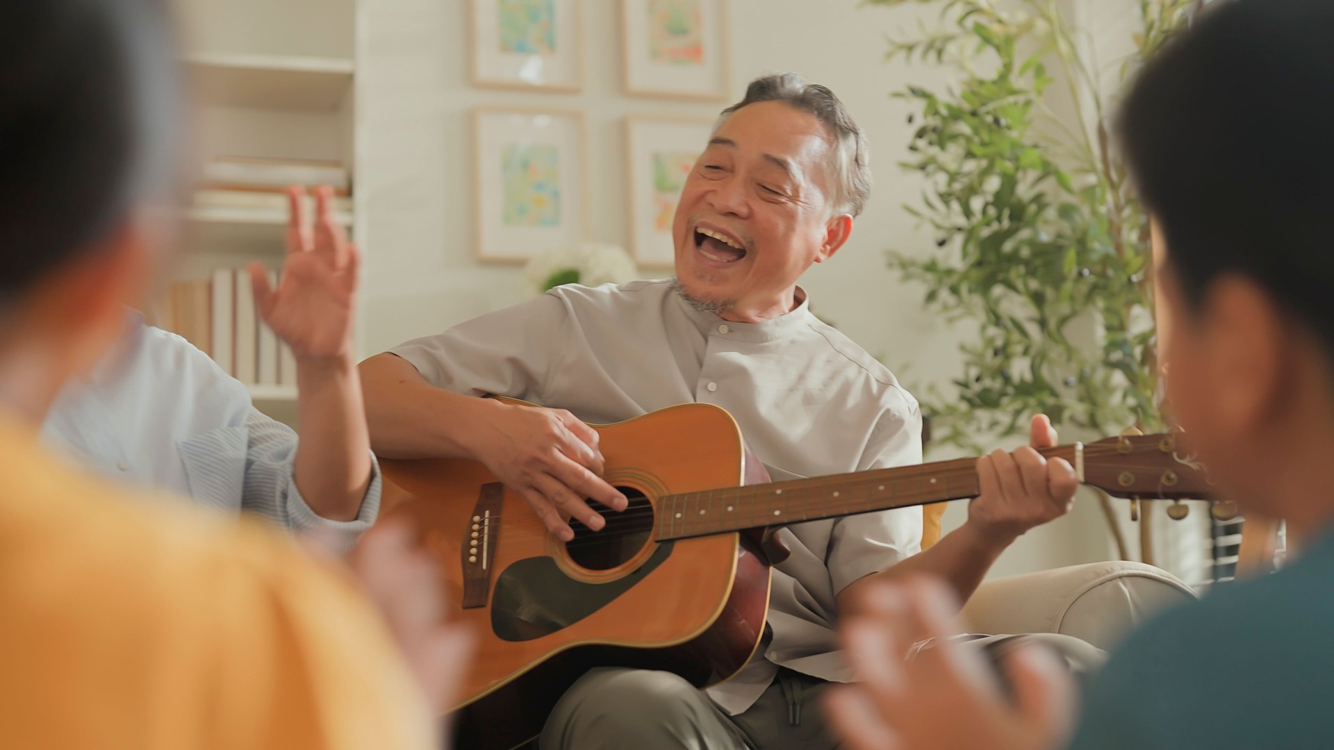 asian family Happy Multi Generation Family is Spending wonderful time at home Grandfather is Playing an Acoustic Guitar while Other Family Members are Singing and Enjoying in Together happy lifestyle